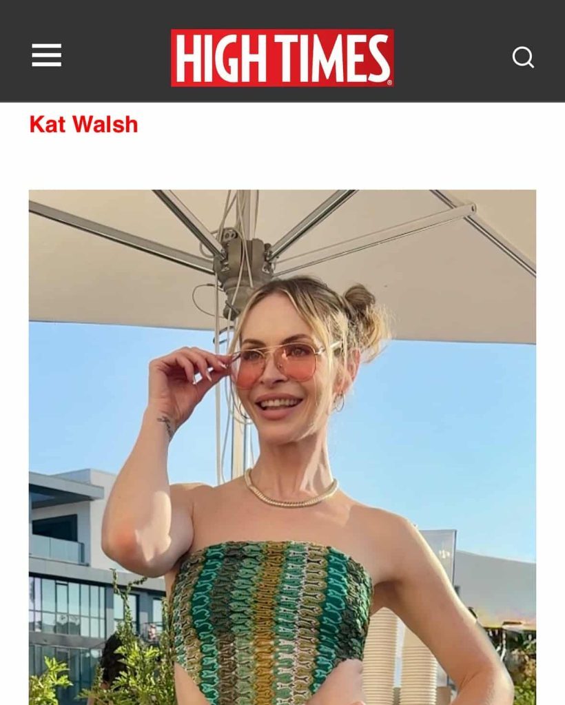 Kat Walsh smiling outdoors in High Times feature, wearing sunglasses and a green patterned top.