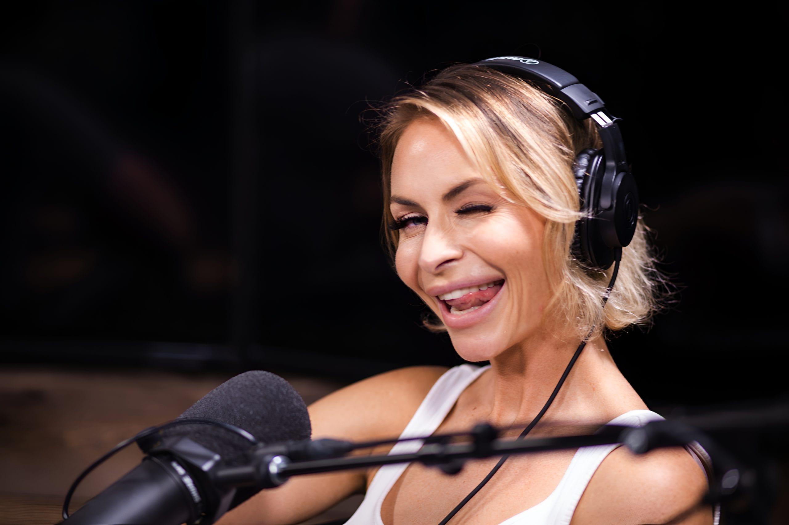 Kat Walsh podcast host winking at camera black bg